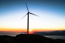 A photo of a wind turbine with a sunset behind it