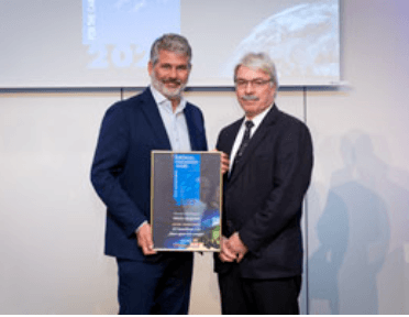 A photo of two men holding the LCI European Innovation award