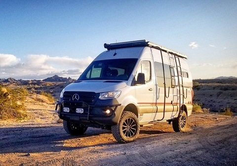 A photograph of an Overland Storyteller Beast Van off-roading in the desert.