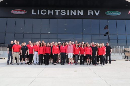 A photograph of approximately 40 members of the Lichtsinn RV staff standing in front of the Iowa dealership location